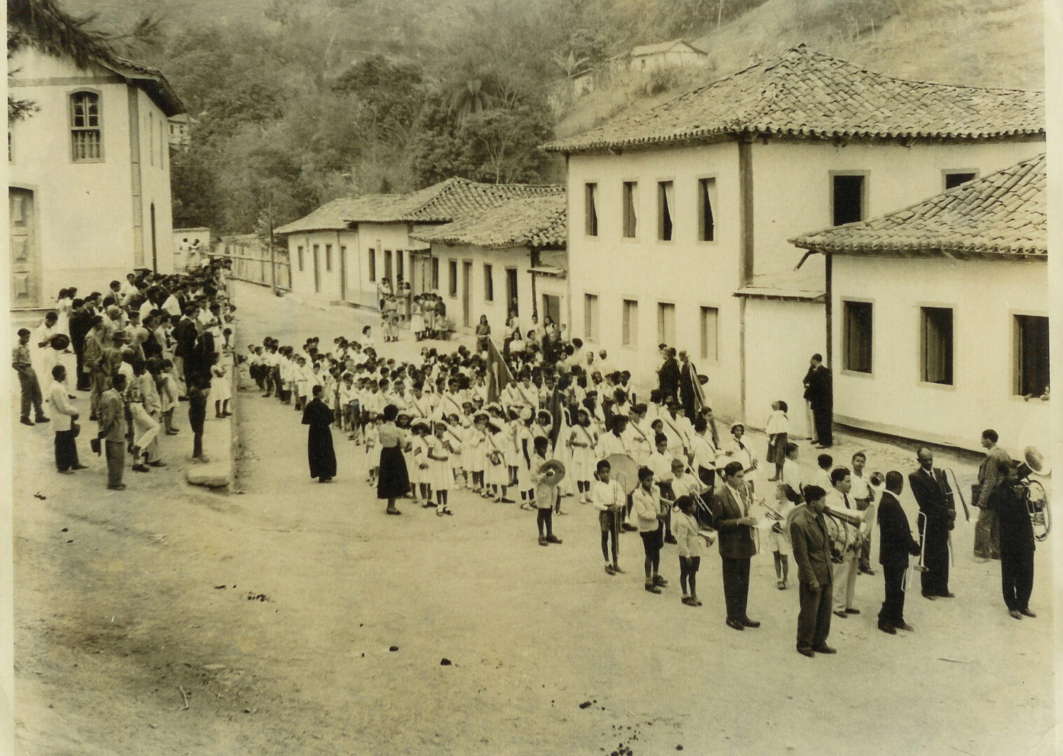 Anos 1950: Festa cívica em 7 de Setembro: estudantes e banda de música reunidos na Rua do Rosário, vendo-se parte da Igreja do Rosário, demolida, e da escola, também jogada ao chão
