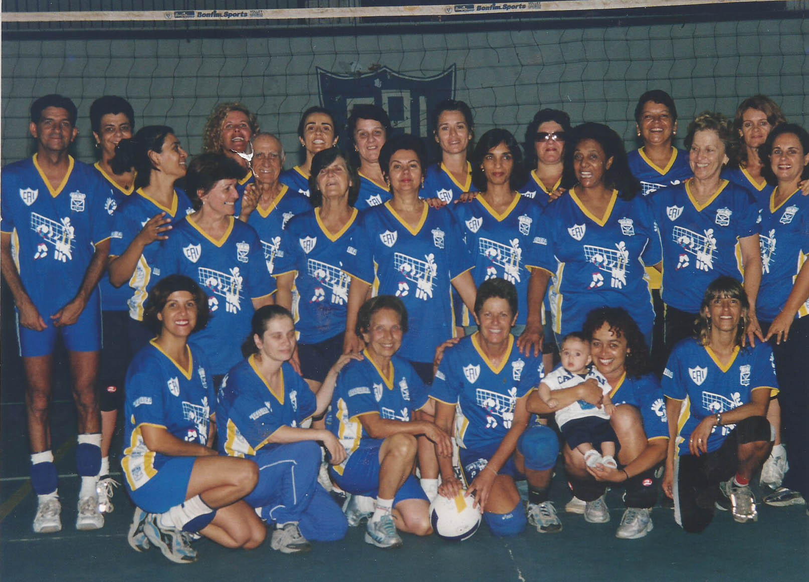A foto acima é de 18 de dezembro de 2003, na quadra do Clube Atlético Itabirano. Estão presentes 26 pessoas (incluindo o bebê que hoje já passou dos 18 anos) e dois “bodes” (Joel Grisolia e o próprio Dr. Colombo)